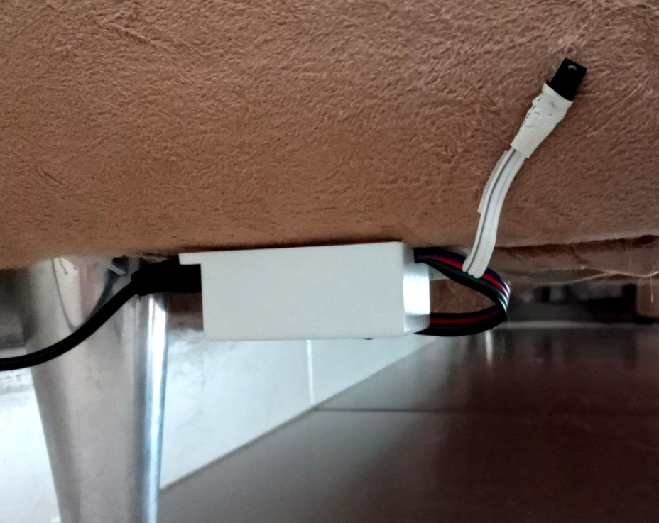 LED controller glued under the sofa, connected to power and
               LEDs, with repaired IR sensor visible.